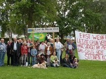 Zirka 25 Demonstranten mit Plakaten im alten Kurpark vor den zu fällenden Bäumen.